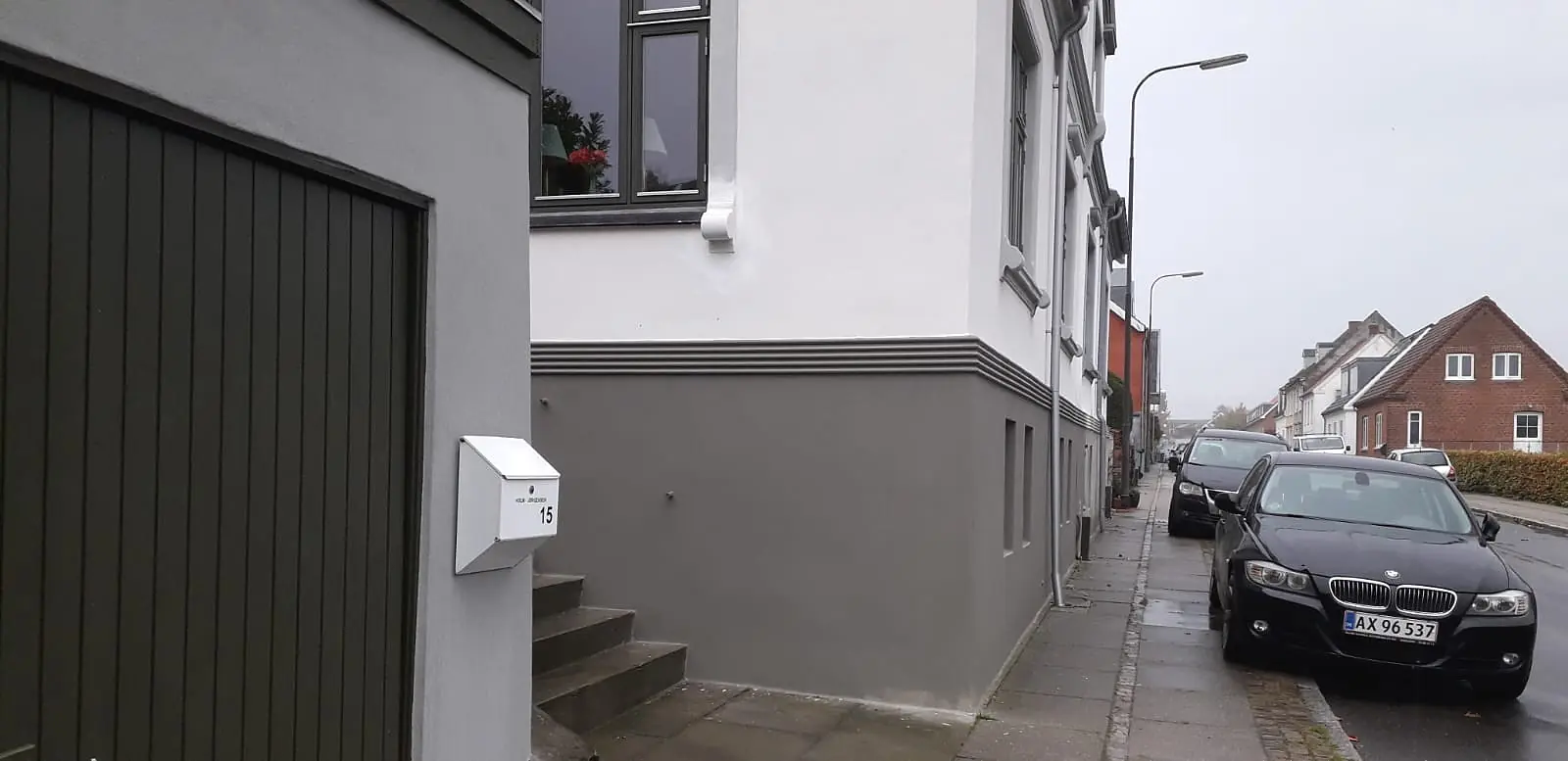 Klassisk villa med færdigrenoveret facade set fra siden